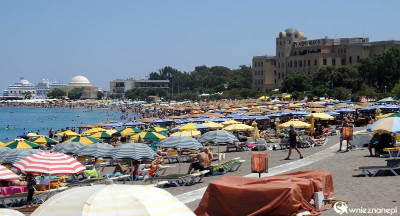 Wyspa Rodos. Zatłoczona plaża w mieście Rodos. W tle wielkie statki i słynny budynek Casino Rodos. - foto: wnieznane.pl Wyspa Rodos. Zatłoczona plaża w mieście Rodos. W tle wielkie statki i słynny budynek Casino Rodos. - foto: wnieznane.pl