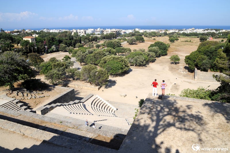Wyspa Rodos. Wzgórze Monte Smith (Agios Stefanos). Na pierwszym planie odrestaurowany marmurowy amfiteatr. W tle drzewa oliwne, wschodnie wybrzeże wyspy i Morze Śródziemne. - foto: wnieznane.pl Wyspa Rodos. Wzgórze Monte Smith (Agios Stefanos). Na pierwszym planie odrestaurowany marmurowy amfiteatr. W tle drzewa oliwne, wschodnie wybrzeże wyspy i Morze Śródziemne. - foto: wnieznane.pl