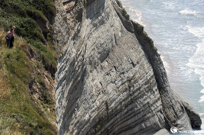 Grecka wyspa Korfu. Przepiękne klifowe wybrzeże w miejscowości Peroulades. Po lewej ludzie stojący na krawędzi klifu. - foto: wnieznane.pl Grecka wyspa Korfu. Przepiękne klifowe wybrzeże w miejscowości Peroulades. Po lewej ludzie stojący na krawędzi klifu. - foto: wnieznane.pl