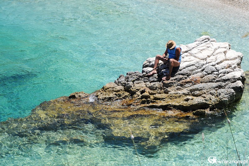 Grecka wyspa Korfu. Rybak łowiący ryby w krystalicznej wodzie. - foto: wnieznane.pl Grecka wyspa Korfu. Rybak łowiący ryby w krystalicznej wodzie. - foto: wnieznane.pl