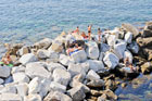 Cinque Terre. Ludzie plażujący na skałach w miejscowości Riomaggiore. - foto: wnieznane.pl Cinque Terre. Ludzie plażujący na skałach w miejscowości Riomaggiore. - foto: wnieznane.pl